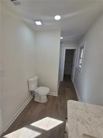 a bathroom with a toilet a sink and mirror