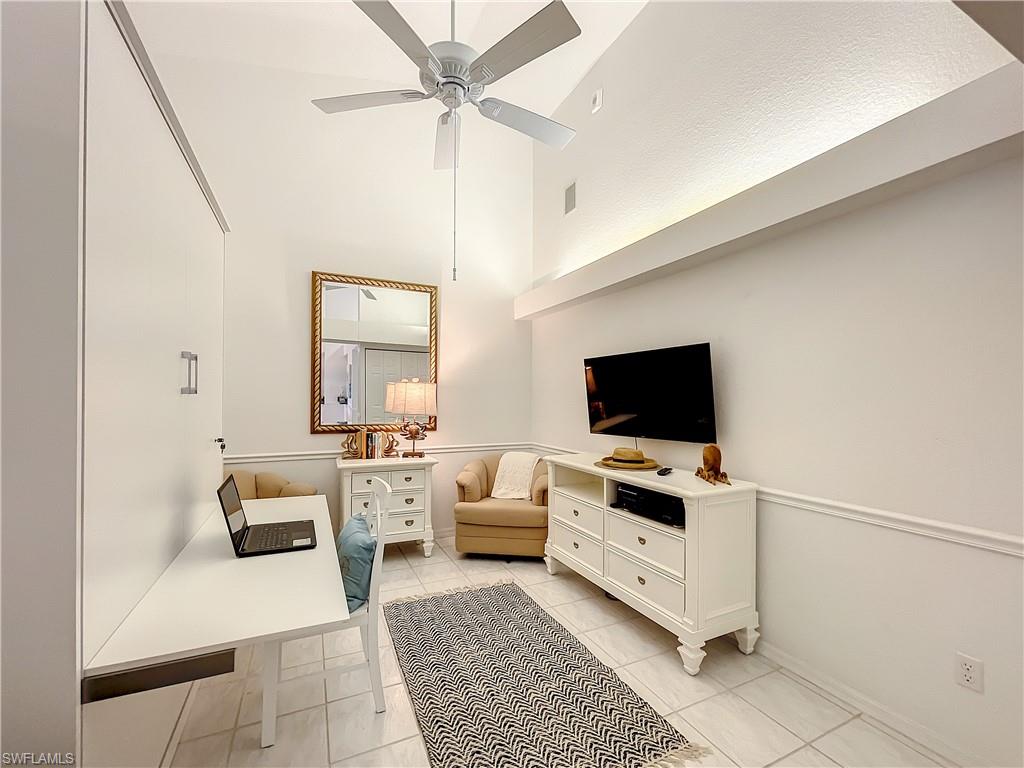 470 Bermuda Cove Way, Unit 2303 Naples, FL 34110 - Photo 11 of 48 a living room with furniture and a flat screen tv