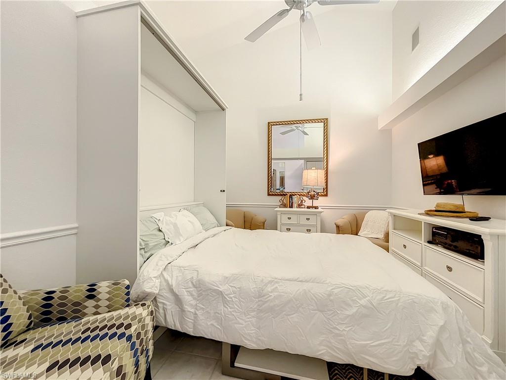 470 Bermuda Cove Way, Unit 2303 Naples, FL 34110 - Photo 15 of 48 a bedroom with a bed and a flat screen tv