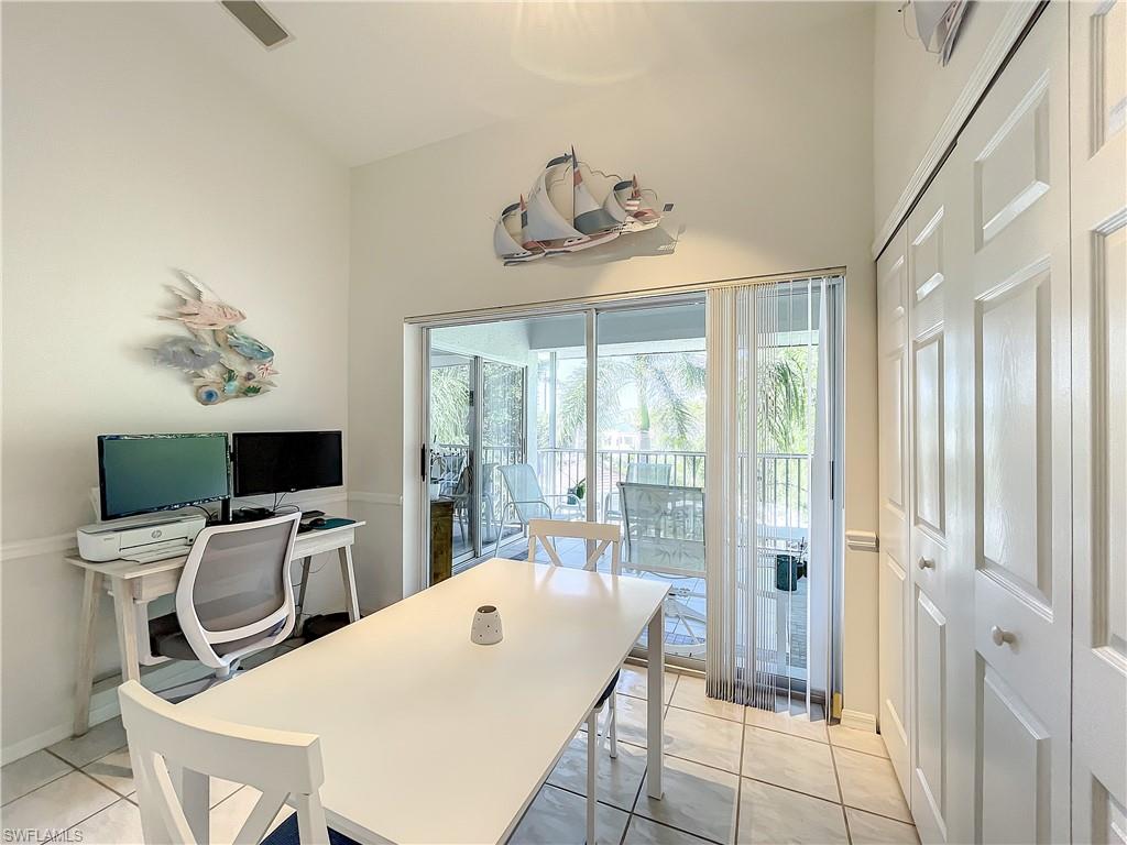 470 Bermuda Cove Way, Unit 2303 Naples, FL 34110 - Photo 18 of 48 a room with a table chairs and a flat screen tv