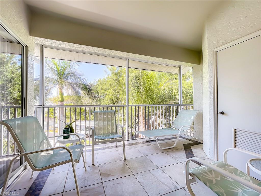 470 Bermuda Cove Way, Unit 2303 Naples, FL 34110 - Photo 19 of 48 a living room with furniture and floor to ceiling windows