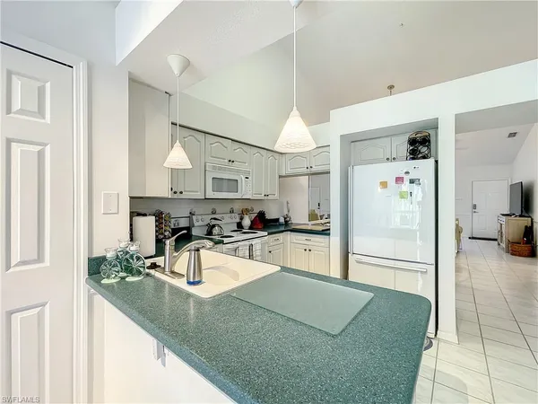 a kitchen with stainless steel appliances granite countertop a sink and a refrigerator
