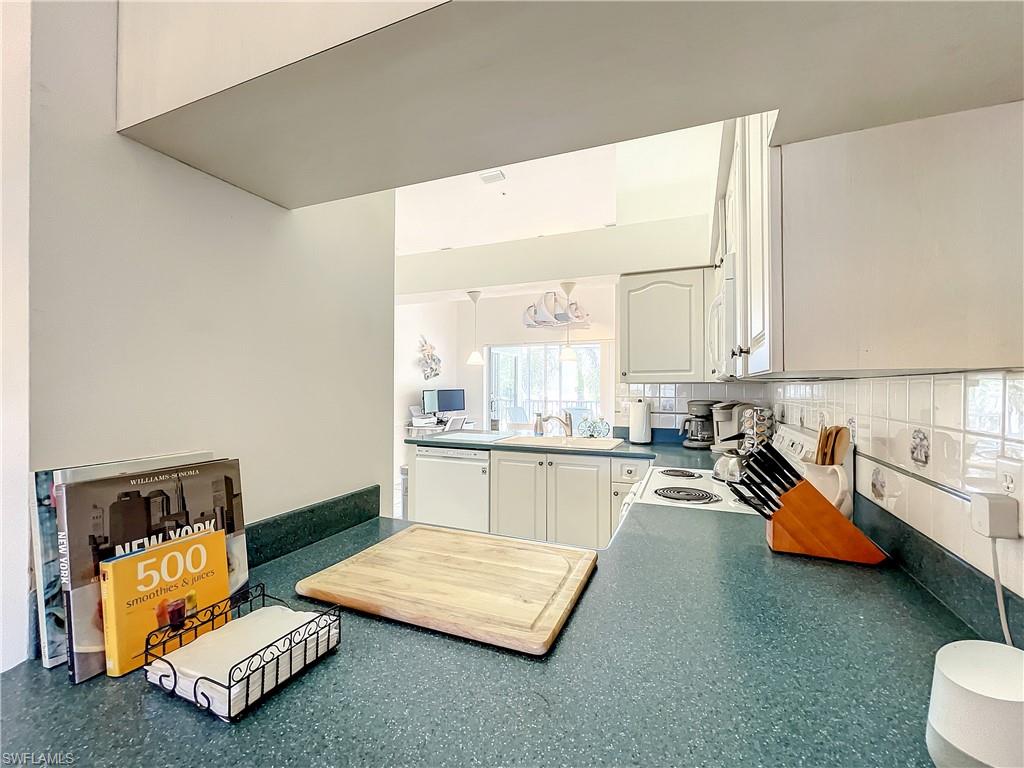 470 Bermuda Cove Way, Unit 2303 Naples, FL 34110 - Photo 42 of 48 a kitchen with a sink and a stove top oven