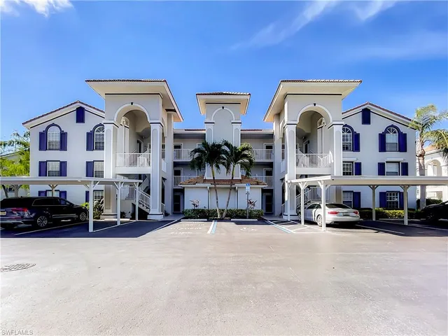 a view of building with cars parked in front of it