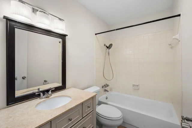 a bathroom with a granite countertop sink toilet and shower