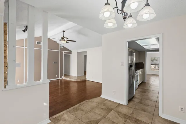 an empty space with wooden floor and a chandelier