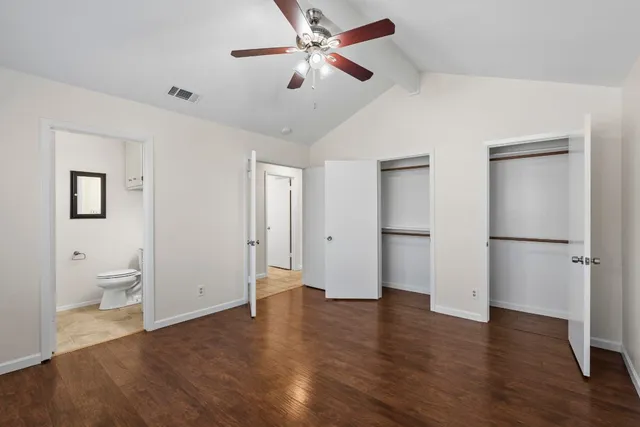 a view of a room with wooden floor and a ceiling fan