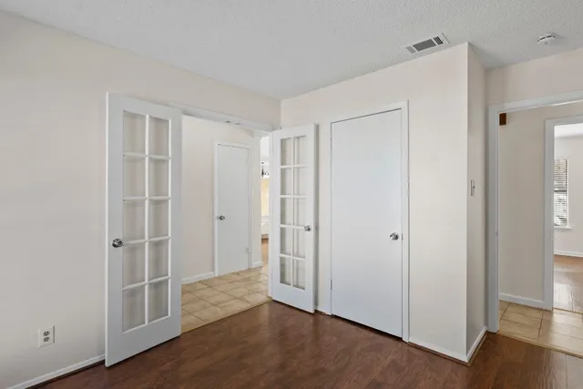 a view of an empty room with wooden floor