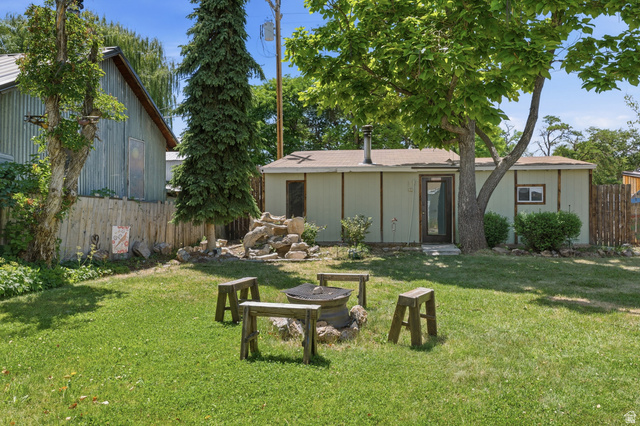 365 North Main Street Fillmore, UT 84631 - Photo 8 of 51 Expansive green lawn featuring a built-in fire pit and custom-crafted wooden seating