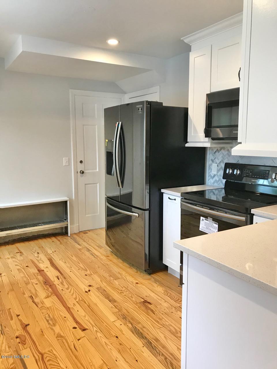 7 River Lane Cos Cob, CT 06807 - Photo 3 of 21 a kitchen with granite countertop a refrigerator and a stove top oven
