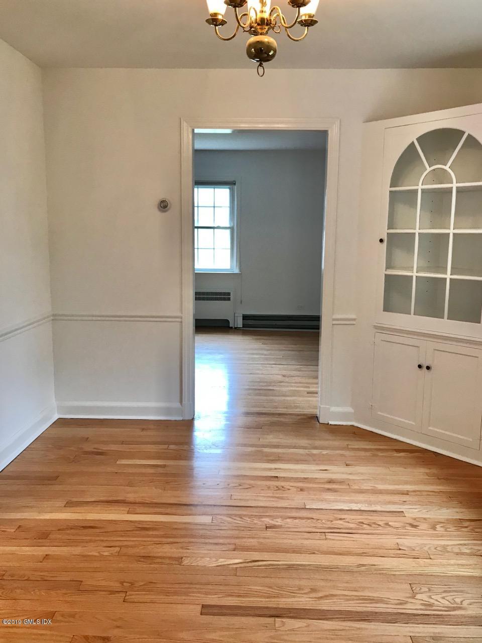 7 River Lane Cos Cob, CT 06807 - Photo 9 of 21 an empty room with wooden floor cabinet and windows