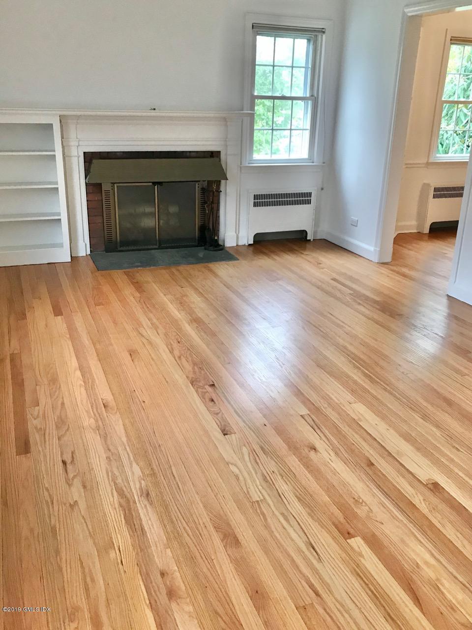 7 River Lane Cos Cob, CT 06807 - Photo 10 of 21 an empty room with wooden floor fireplace and windows