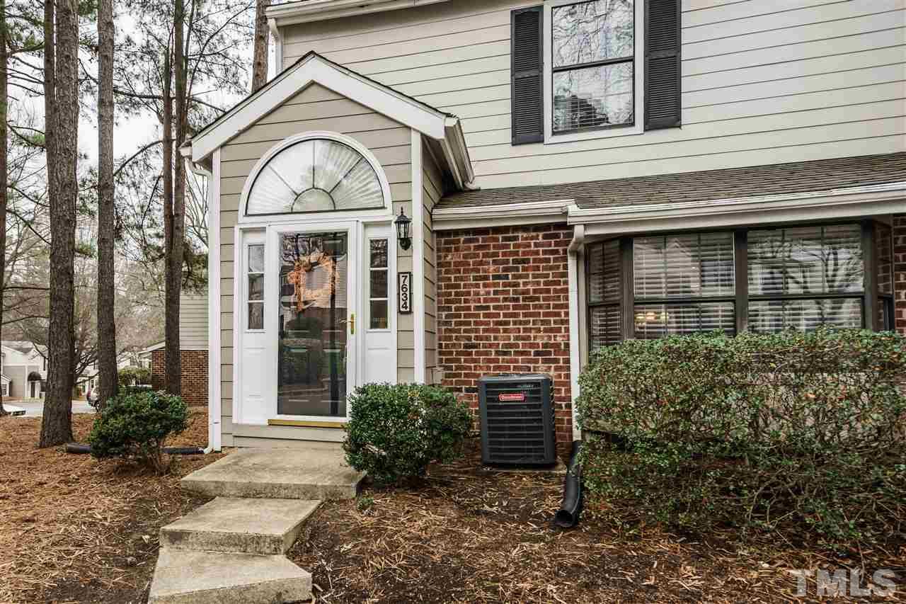 7634 Falcon Rest Circle, Unit 7634 Raleigh, NC 27615 - Photo 2 of 25 a view of a brick house with plants and large tree