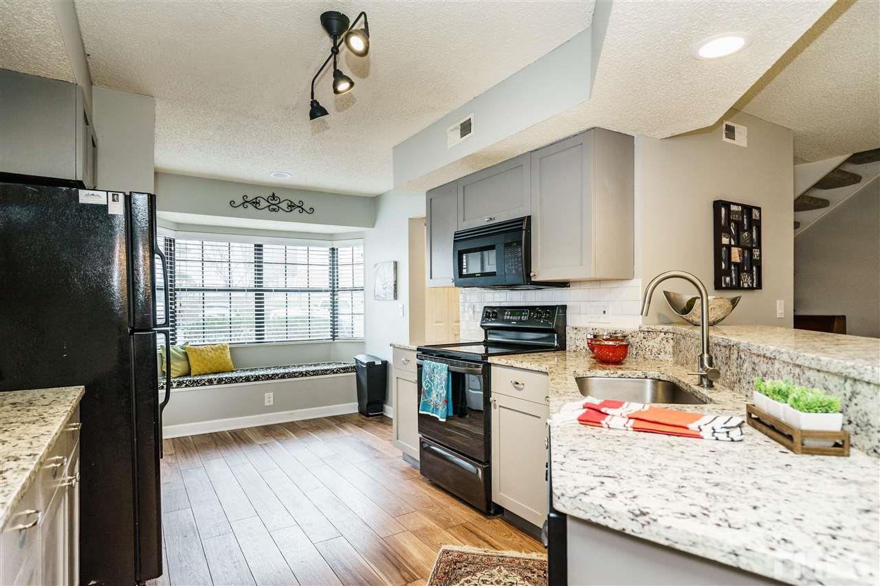 7634 Falcon Rest Circle, Unit 7634 Raleigh, NC 27615 - Photo 11 of 25 a kitchen with granite countertop a stove a sink and a refrigerator