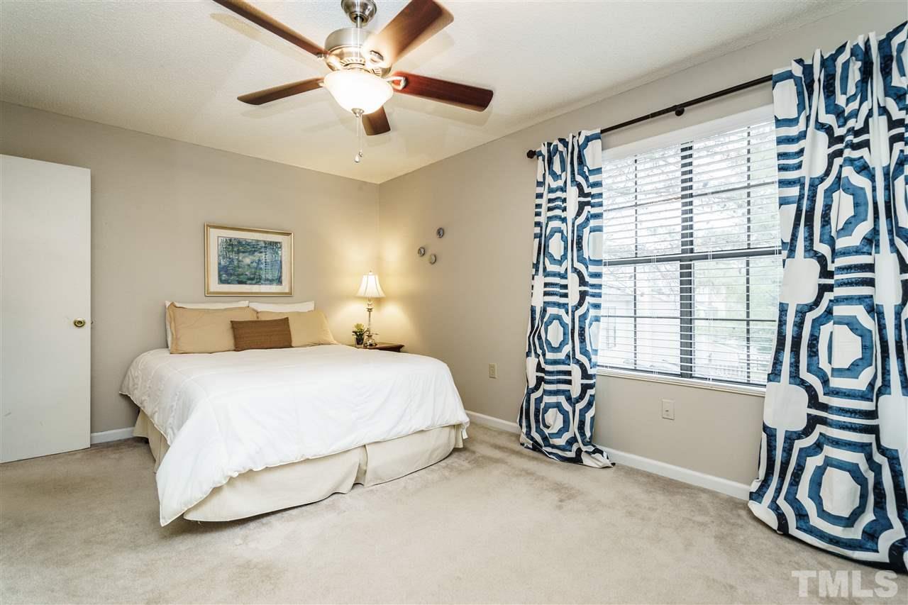 7634 Falcon Rest Circle, Unit 7634 Raleigh, NC 27615 - Photo 17 of 25 a spacious bedroom with a bed and a chandelier