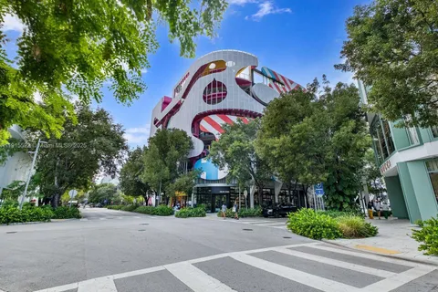 a front view of multi story residential apartment building with yard and sign board