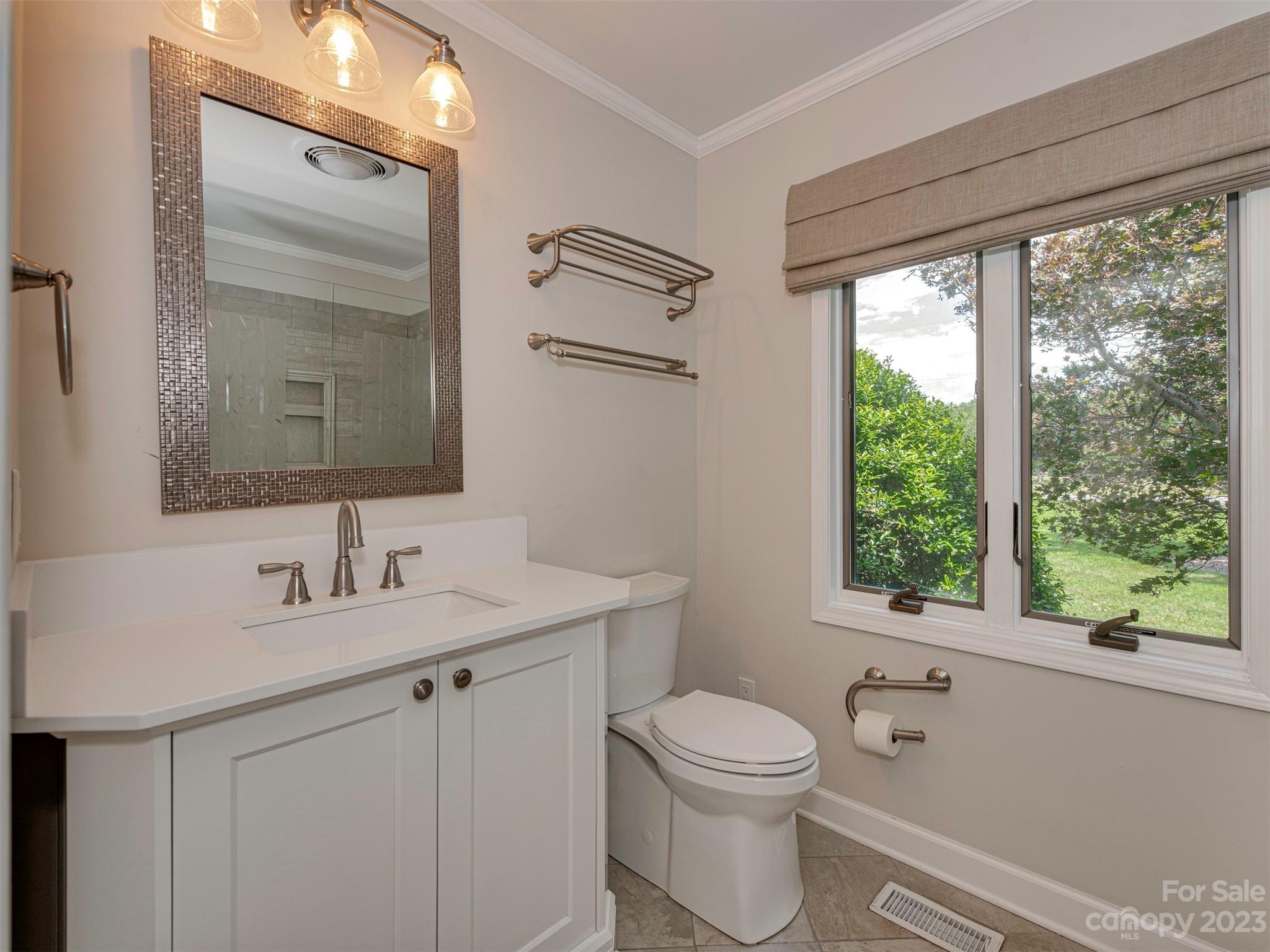 136 Patrick Road Gastonia, NC 28056 - Photo 16 of 22 a bathroom with a toilet a sink a window and mirror