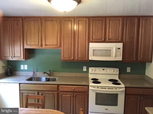 9331 Pan Ridge Road Baltimore, MD 21234 - Photo 3 of 8 a kitchen with cabinets a stove and a microwave