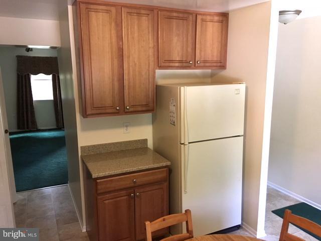 9331 Pan Ridge Road Baltimore, MD 21234 - Photo 4 of 8 a white refrigerator freezer and a stove sitting inside of a kitchen