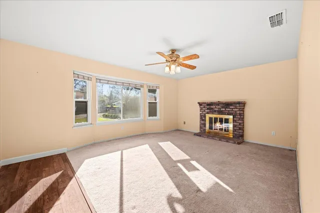 an empty room with windows and fireplace