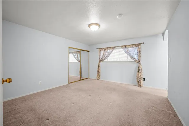 an empty room with windows and closet