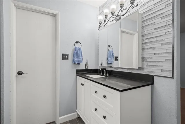 a bathroom with a granite countertop sink and a mirror