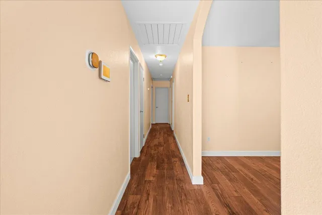 a view of a hallway with wooden floor