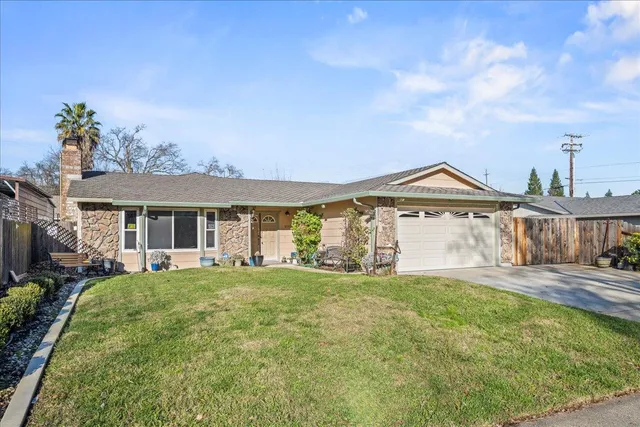 a front view of a house with a garden and yard