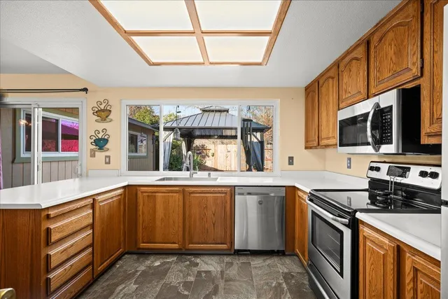 a kitchen with stainless steel appliances a stove sink microwave and cabinets
