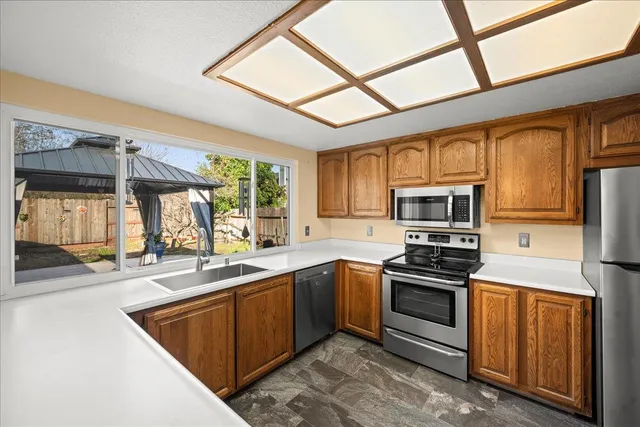 a kitchen with stainless steel appliances granite countertop a stove sink and microwave