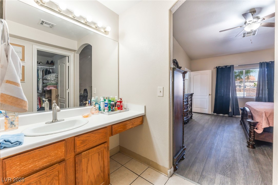 4656 East Desert Inn Road Las Vegas, NV 89121 - Photo 81 of 98 4652 E DI Bathroom featuring vanity, ceiling fan, a walk in closet, and tile patterned flooring