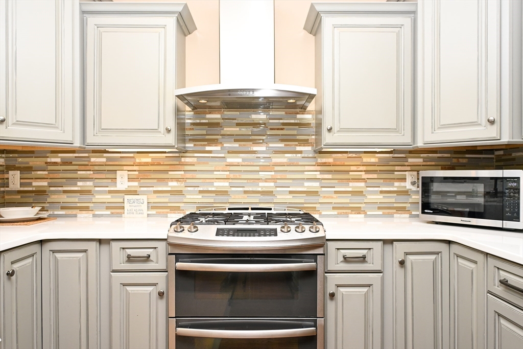 60 Harding Street, Unit C Medfield, MA 02052 - Photo 7 of 41 a kitchen with granite countertop white cabinets and white appliances