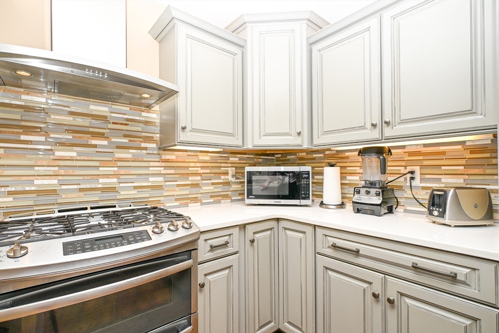 60 Harding Street, Unit C Medfield, MA 02052 - Photo 8 of 41 a kitchen with a stove and white cabinets