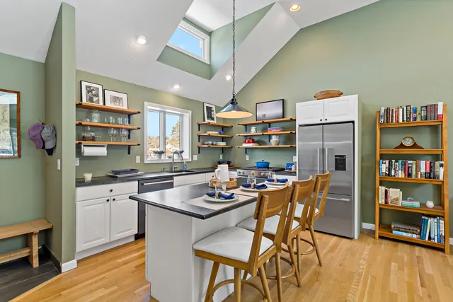 a kitchen with stainless steel appliances granite countertop a table chairs stove and cabinets