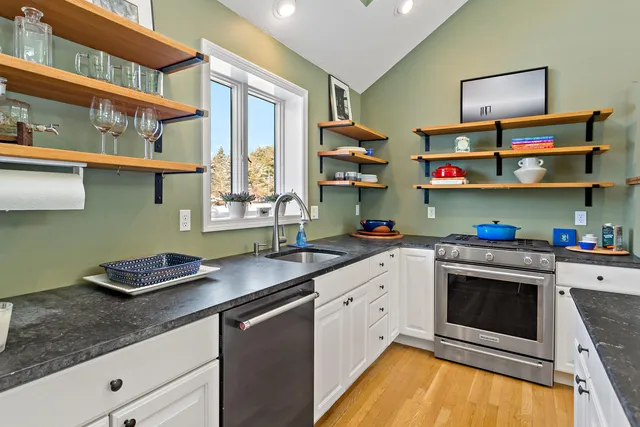 a kitchen with stainless steel appliances granite countertop a sink and cabinets
