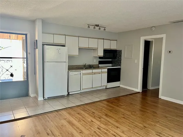 a kitchen with a refrigerator a stove top oven and a counter space