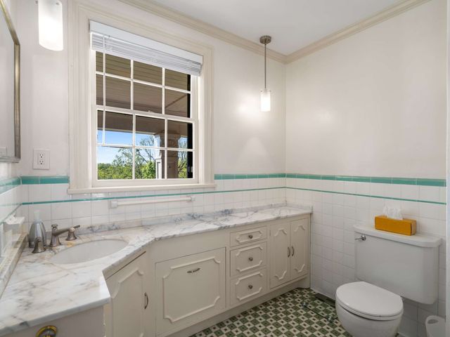 a bathroom with a sink a toilet and a window