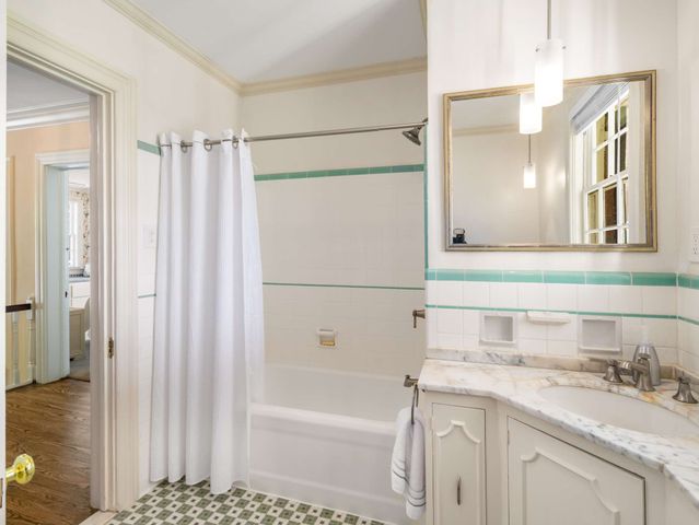a bathroom with a granite countertop sink a mirror a shower and a bathtub