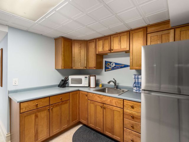 a kitchen with stainless steel appliances granite countertop a sink a refrigerator and cabinets