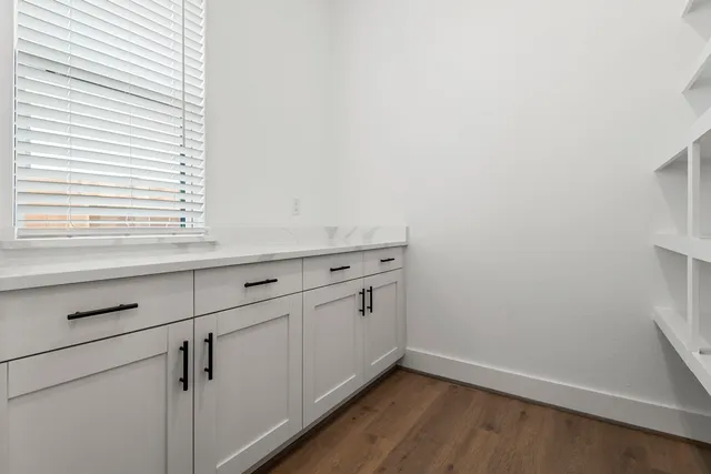a view of a kitchen with wooden floor and white walls