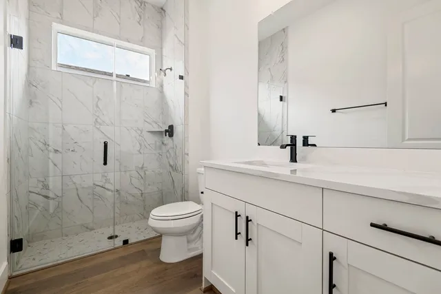 a bathroom with a sink a toilet and shower