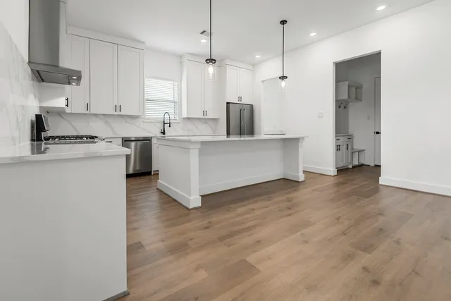 a kitchen with white cabinets and stainless steel appliances