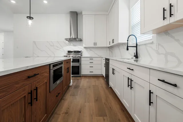 a kitchen with white cabinets stainless steel appliances and sink