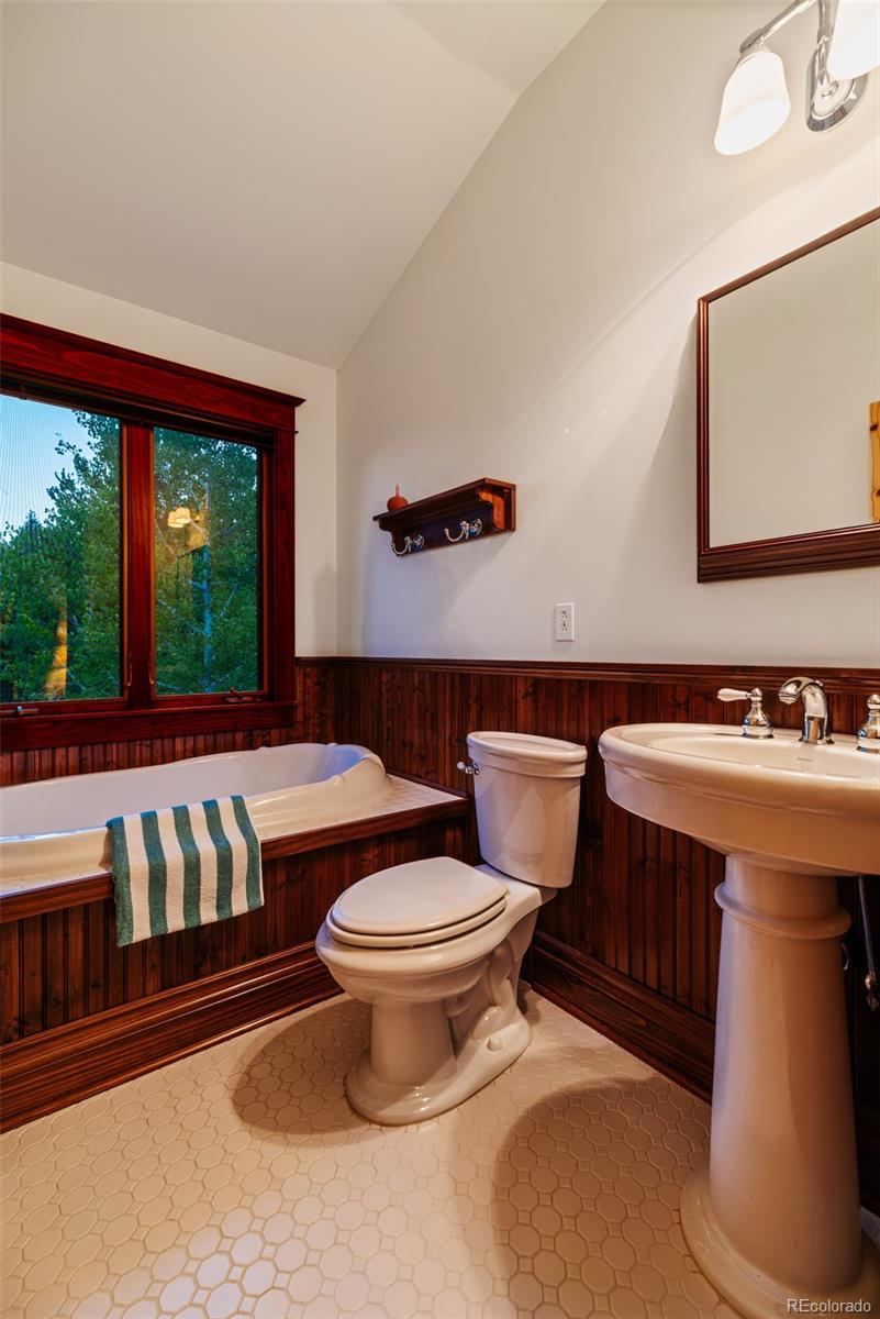 1023 Raven Way Como, CO 80432 - Photo 17 of 40 a bathroom with a toilet a sink and a large mirror
