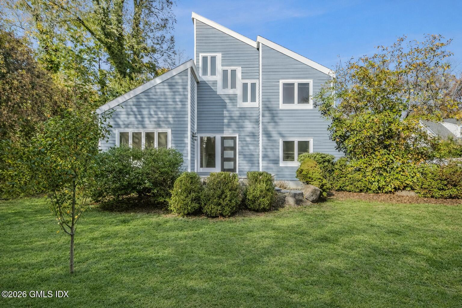 145 R Shore Road Old Greenwich, CT 06870 - Photo 3 of 40 Modern house with green foliage