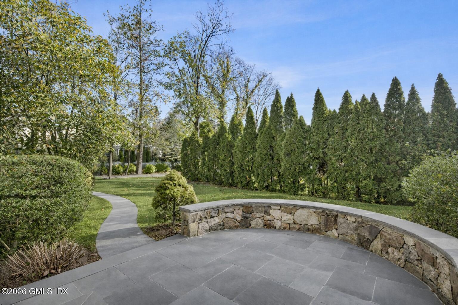 145 R Shore Road Old Greenwich, CT 06870 - Photo 4 of 40 Curved stone patio in landscaped garden