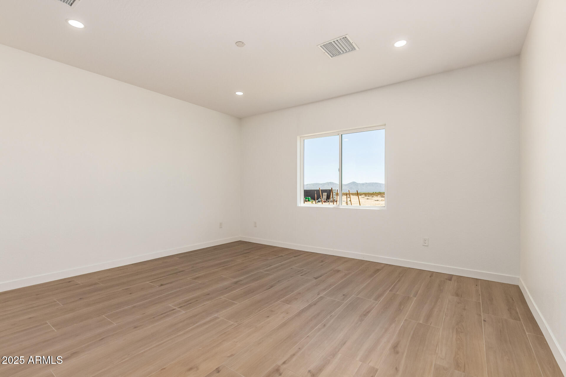 25117 West McArthur Road Wittmann, AZ 85361 - Photo 18 of 43 an empty room with wooden floor and windows