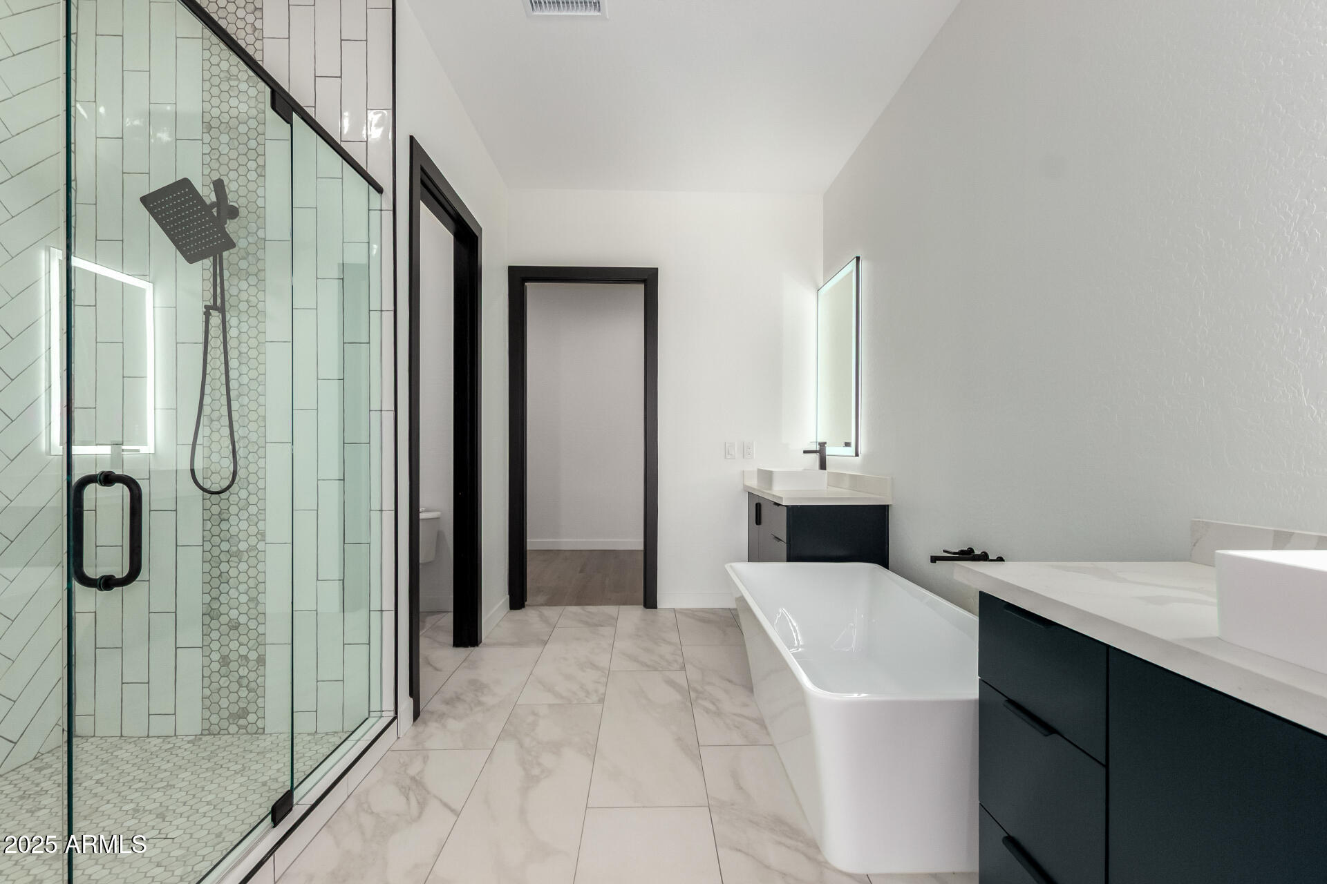 25117 West McArthur Road Wittmann, AZ 85361 - Photo 22 of 43 a en suite bathroom with a sink a mirror and shower