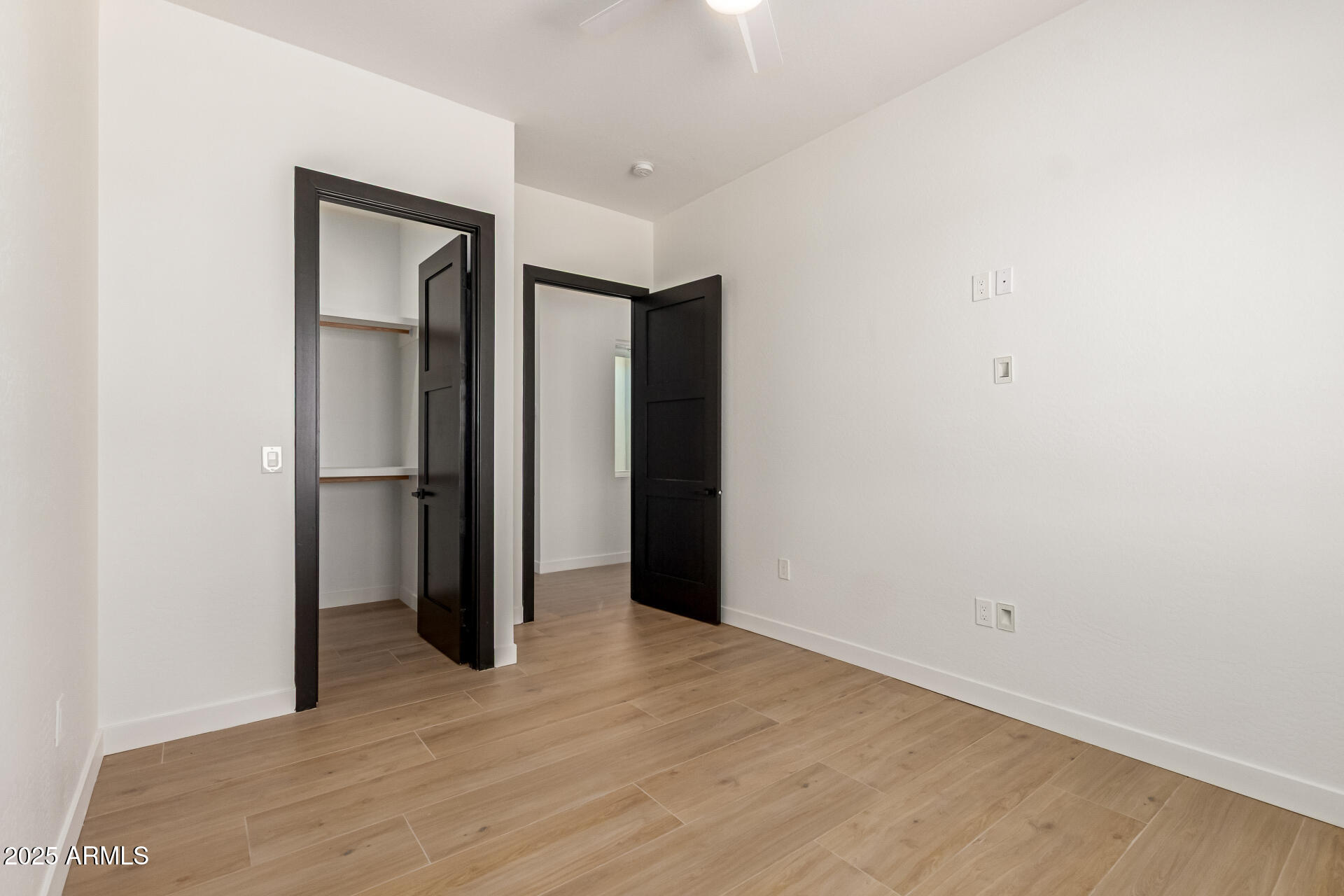 25117 West McArthur Road Wittmann, AZ 85361 - Photo 31 of 43 a view of an empty room with wooden floor and closet