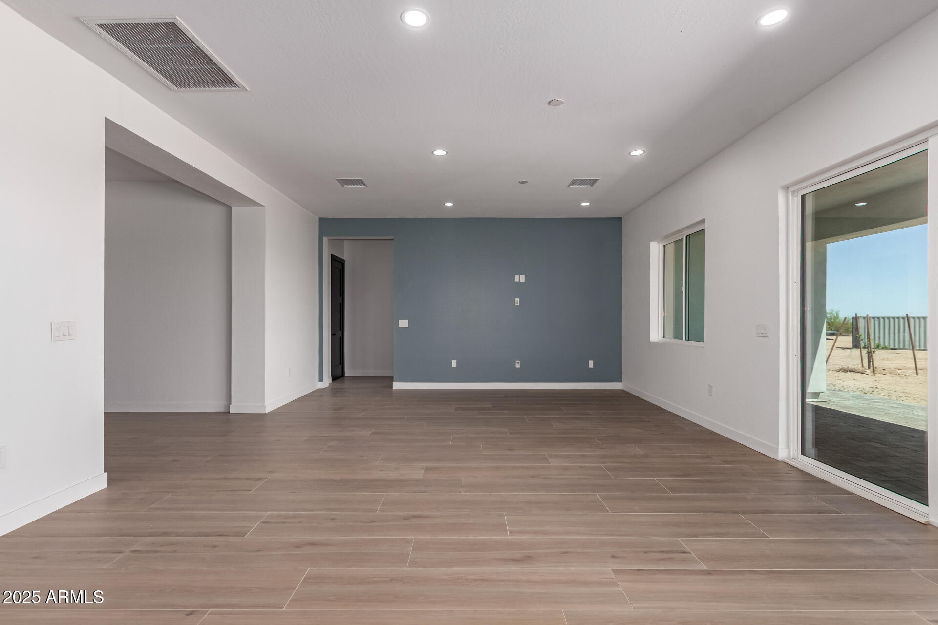 25117 West McArthur Road Wittmann, AZ 85361 - Photo 4 of 43 a view of an empty room with wooden floor and a bathroom